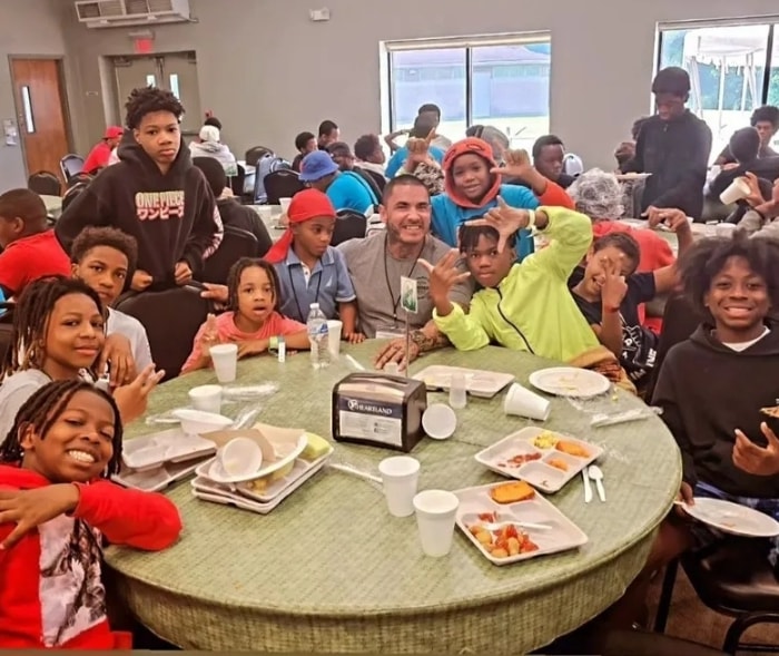 Julio surrounded by kids at a community event