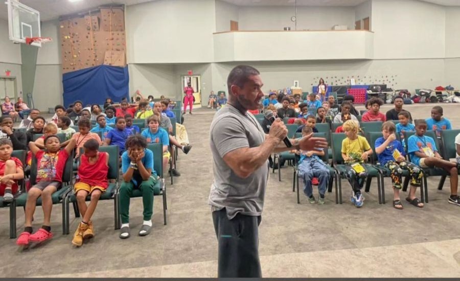 Julio speaking to youth at a gymnasium — Camp CAN